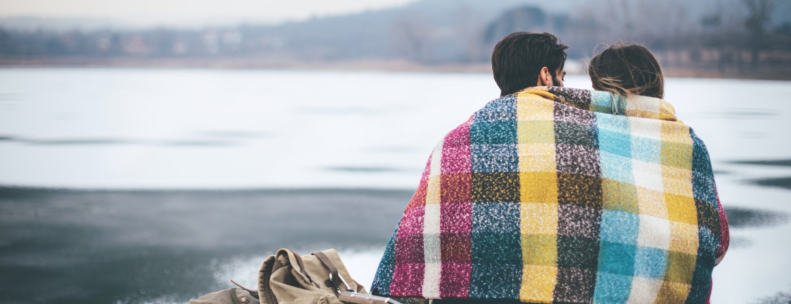 Couple on cold winter day in nature, having fun